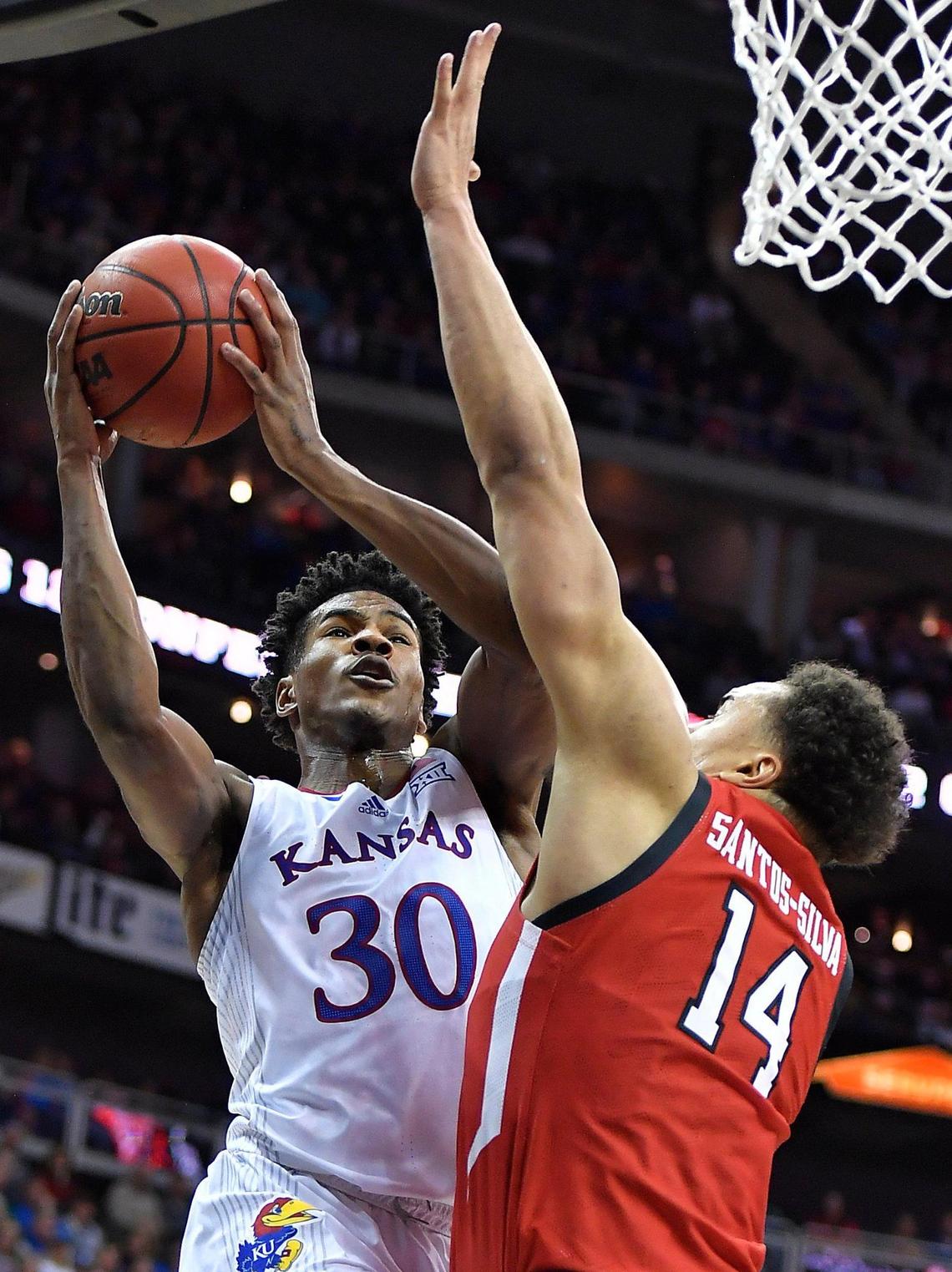 KU’s Ochai Agbaji drives to the basket on Texas Tech’s Marcus Santos-Silva during the first half Saturday’s Big 12 Tournament championship game at the T-Mobile Center in Kansas City.