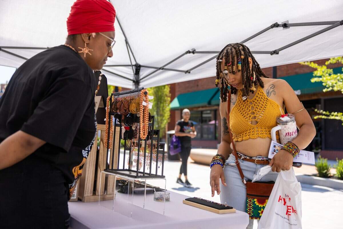 Courtney Graham, owner of The Copper Crystal Cabinet, left, helps customer Kellen Walker pick out a nose ring during JuneteenthKC 15th Annual Heritage Festival at E 18th Street on Friday, June 19, 2026.