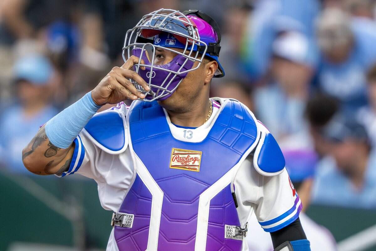 Wearing the Kansas City Royals' new "Forever Fountains" City Connect uniform, catcher Salvador Perez (13) puts on his catcher's mask during a game against the Houston Astros on Friday, June 12, 2026, at Kauffman Stadium in Kansas City.
