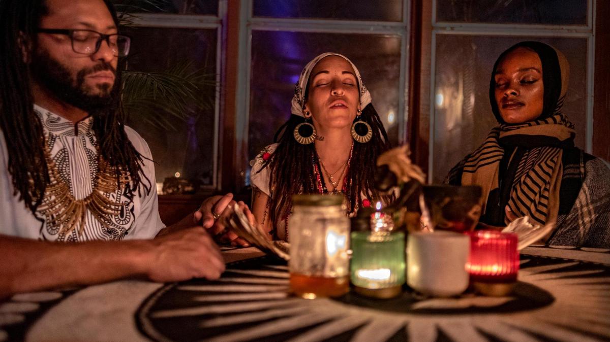 Nicolette Paige, center, leads a new moon ceremony with Darrian Davis and Shae Bradley at her Kansas City home earlier this month.