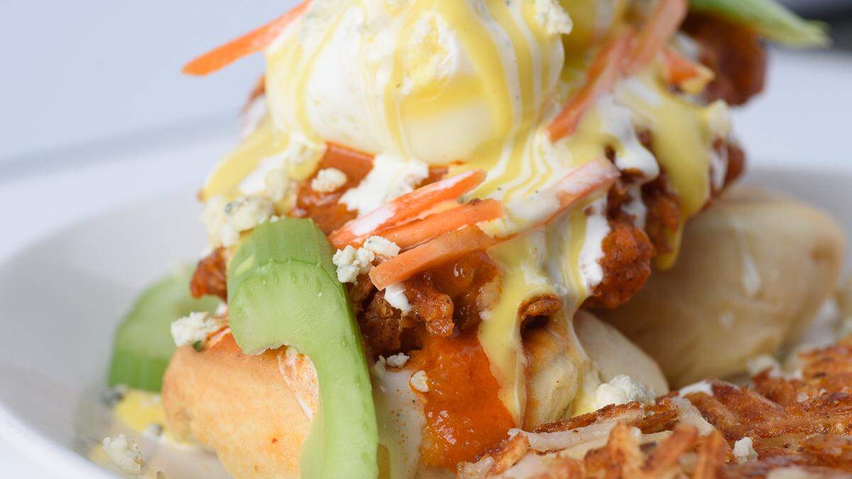 The Denver hot chicken eggs Benedict has lightly fried chicken, roasted chili buffalo sauce, buttermilk biscuit, ranch, hollandaise sauce, blue cheese, celery and carrots.
