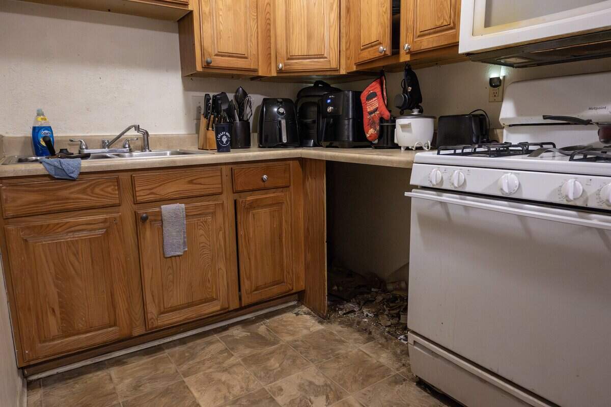 An empty space where a dishwasher once sat is filled with debris in the kitchen of Mikayla Daniels' apartment at Sage Crossing Apartments on Wednesday, Sept. 17, 2025, in Lee's Summit.