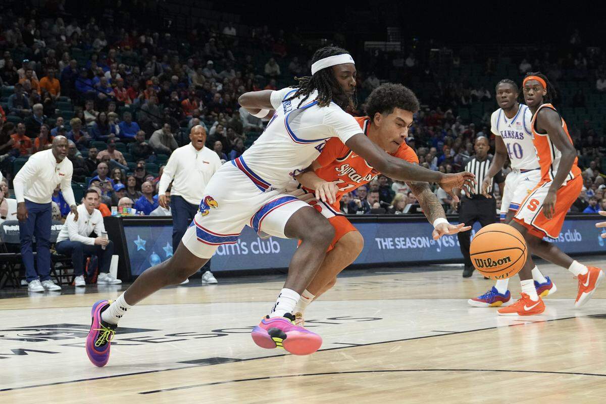 Naithan George #11 of the Syracuse Orange and Jamari McDowell #11 of the Kansas Jayhawks chase after a loose ball in the first half of their game during the Players Era Championship basketball tournament at Grand Garden Arena on November 25, 2025 in Las Vegas.
