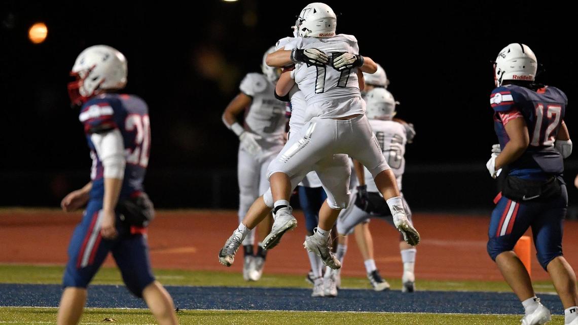 Blue Valley North teammates David Sjoberg (77) and Jaxson Townsend celebrate their win over Olathe North during the fourth quarter of Friday night’s Kansas State semi-final game at the Olathe District Athletic Center.