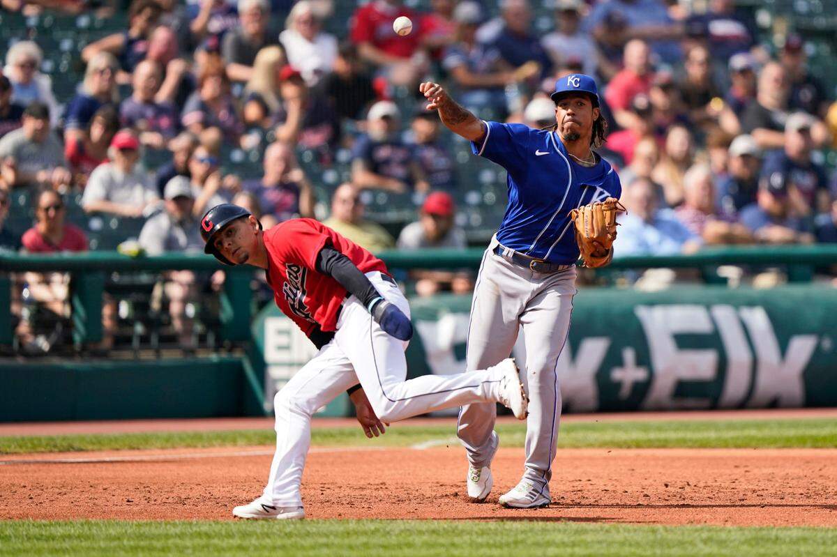 Kansas City Royals’ Adalberto Mondesi, right, throws out Cleveland Indians’ Myles Straw at first base as Andres Gimenez runs by in the second inning of a baseball game, Monday, Sept. 27, 2021, in Cleveland. (AP Photo/Tony Dejak)
