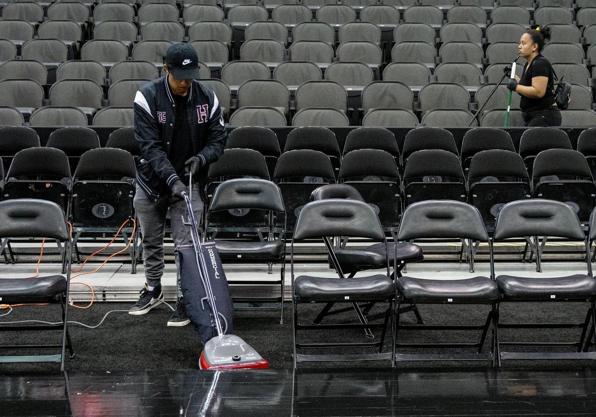 Environmental services team members at T-Mobile Center clean around seats during the Big 12 basketball tournament on Tuesday, March 12, 2024, in Kansas City.