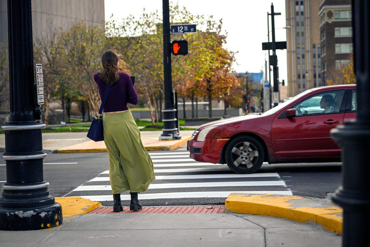 A pedestrian waits to cross E. 12th Street at Locust Street on Nov. 7 in Kansas City.
