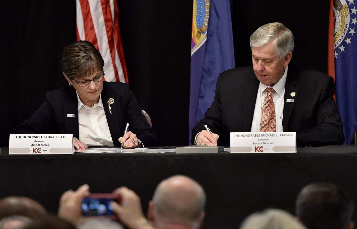 Kansas Gov. Laura Kelly, left, and Missouri Gov. Mike Parson signed an agreement in August 2019 ending the economic border war between the two states.