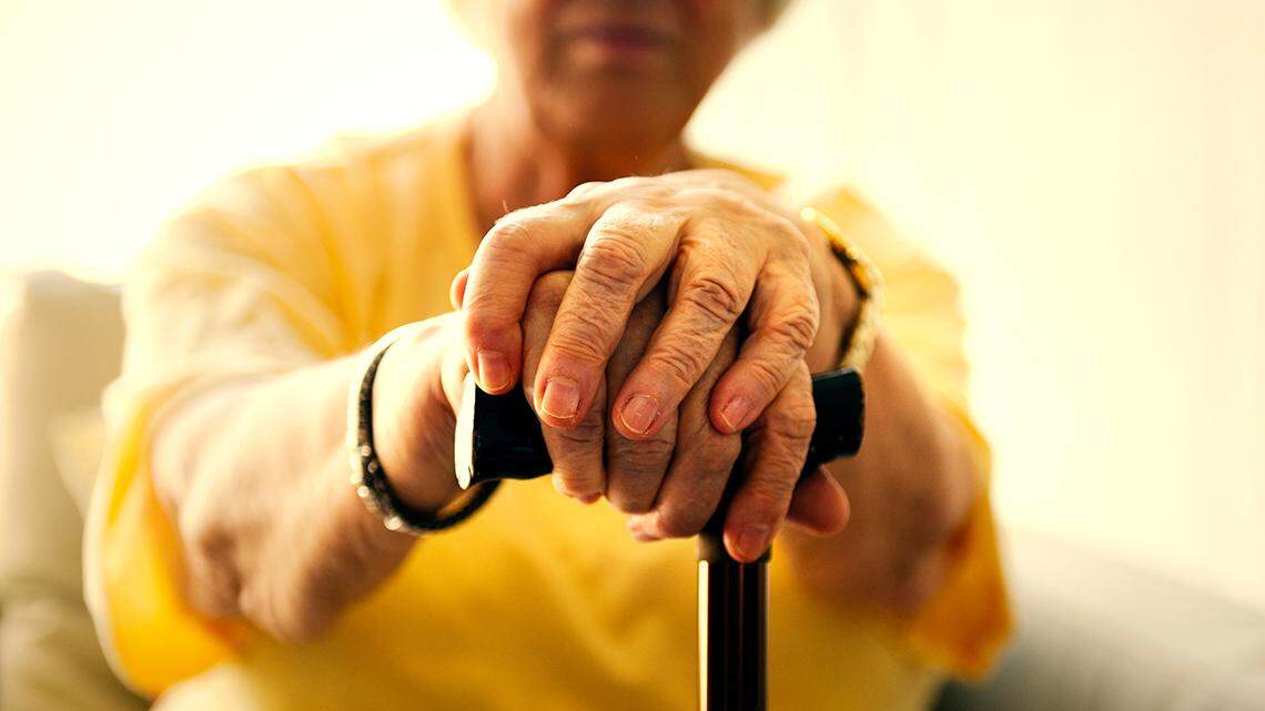 Senior woman holding a walking stick.