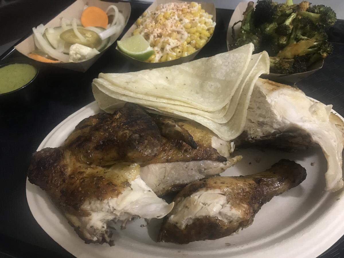 POI-Ō’s wood-fired chicken with sides of elotes (Mexican street corn) and charred broccoli with Chile and lime.