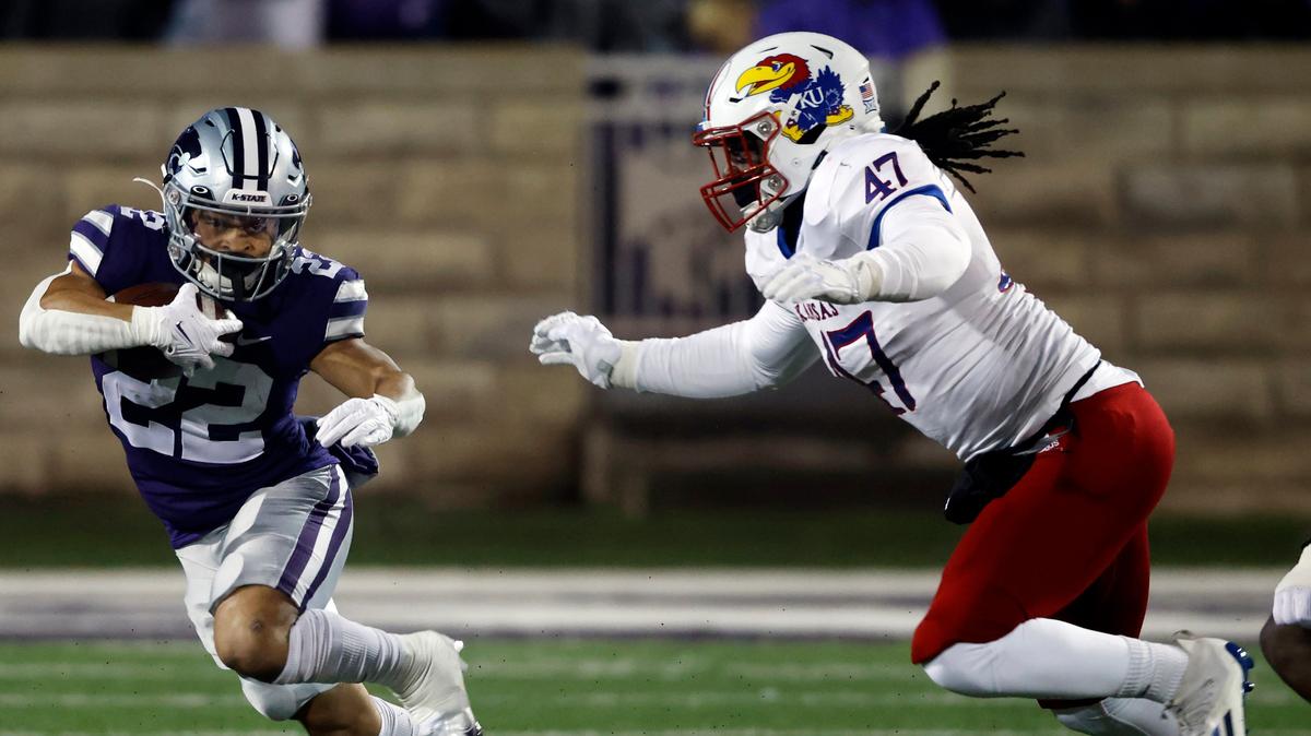Kansas defensive end Lonnie Phelps chases after K-State RB Deuce Vaughn during a game in Manhattan, Kan., on Nov. 26, 2022. Both Phelps and Vaughn have declared for the 2023 NFL Draft.