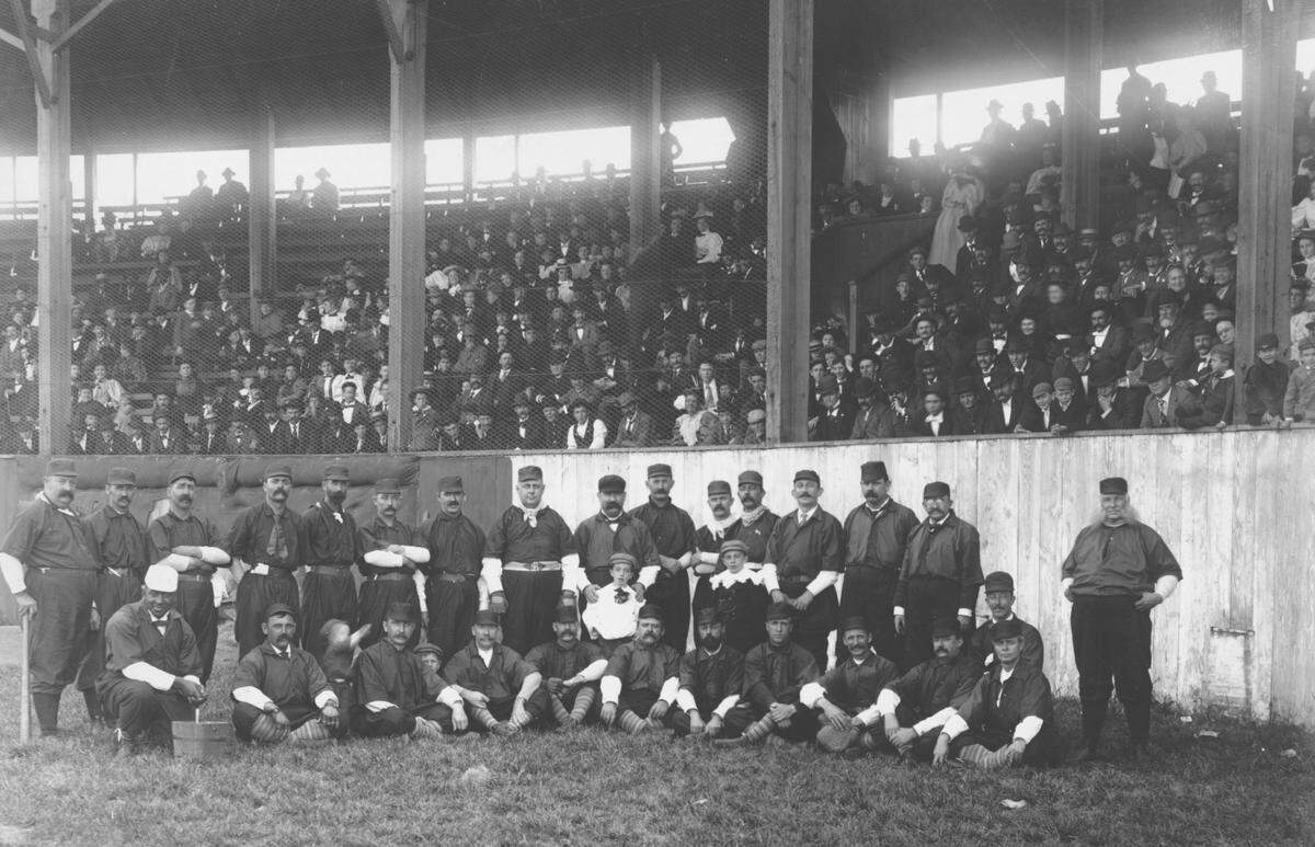 Unidentified Kansas City baseball team with dozens of fans in the grandstand, 1880.