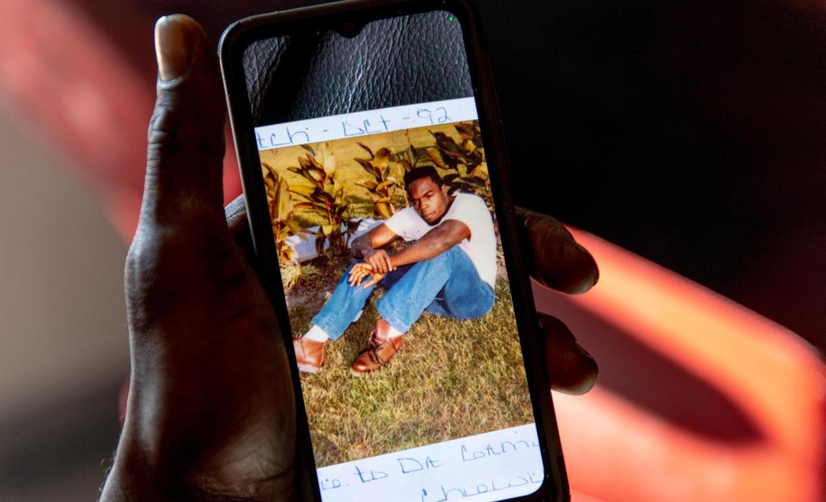 Dion Martin shows a photo of himself at age 19 on Monday, Nov. 28, 2022, in Kansas City, Kan.