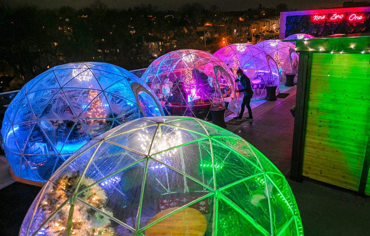 Server Travis Jones steps out of a holiday-decorated igloo where guests were tucked inside with cocktails and appetizers in 2022 at Nine Zero One Igloo Bar & Lounge on the rooftop at The Fontaine, a hotel on the Country Club Plaza.