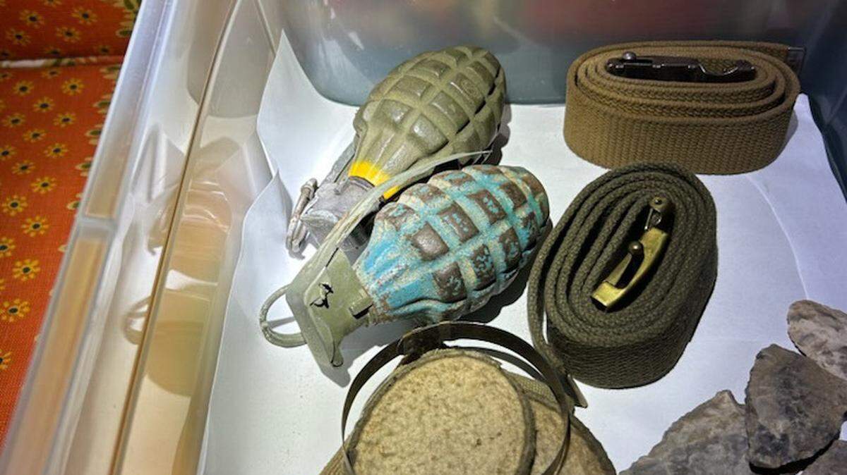 Two World War II grenades were discovered by movers in the basement of a man’s Prairie Village home, seen here in a box with rocks, belts, and other items. A bomb squad safely removed them and have been unable to determine if they were live.