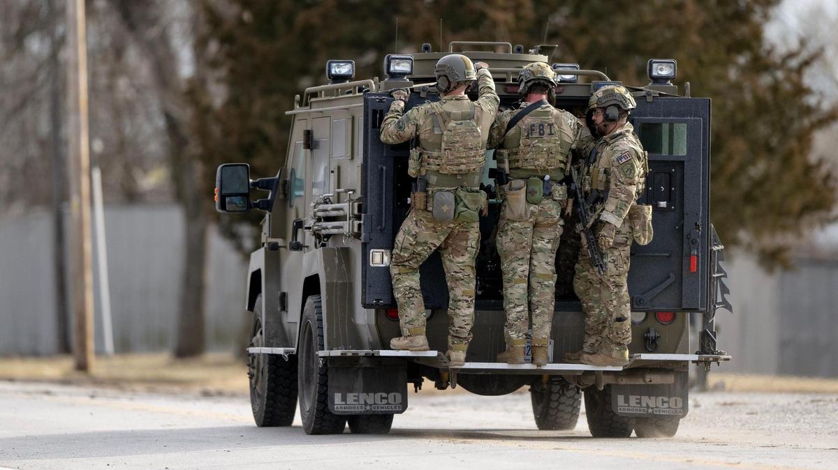 FBI SWAT team members leave the scene of a standoff in the 2300 block of Blue Ridge Boulevard on Wednesday, March 1, 2023, in Kansas City.