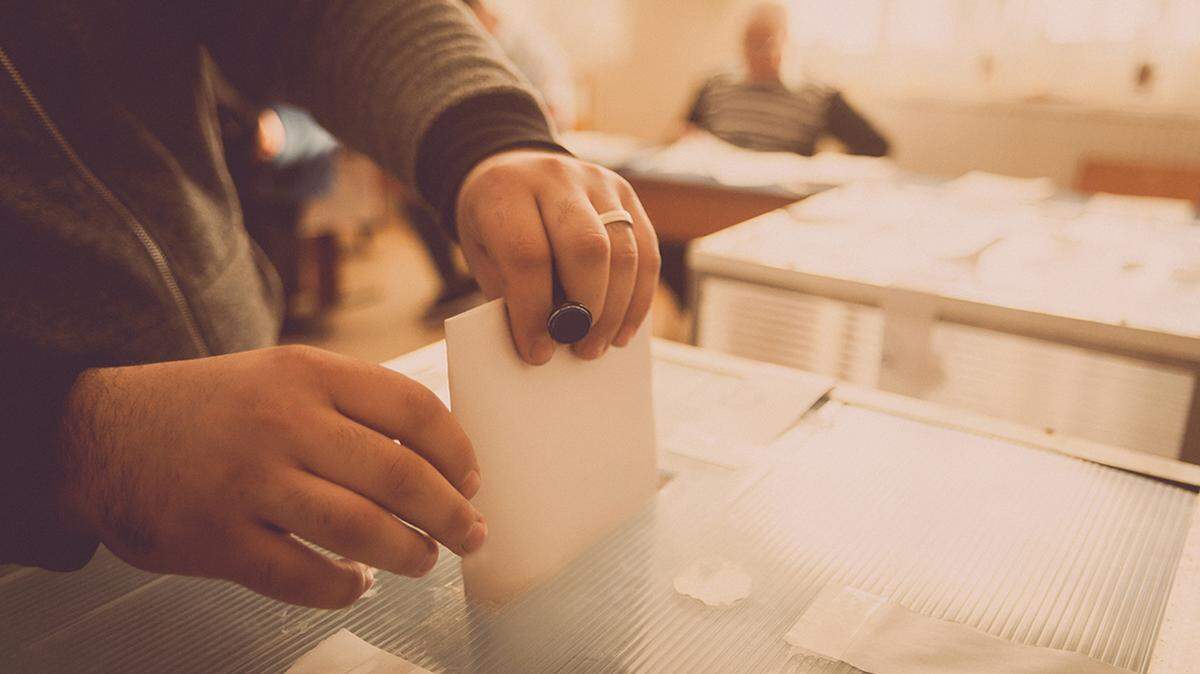A person casts her ballot during voting for elections at a polling station