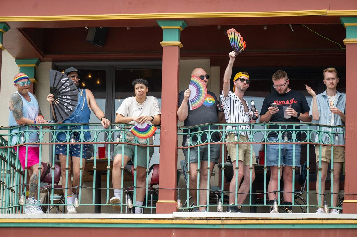 Men watched the KC Pride Parade from a restaurant balcony at the Country Club Plaza on Saturday.