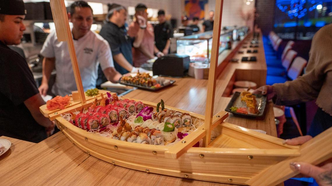 Various sushi rolls are served on a wooden sailboat platter at Blue Sushi Sake Grill.