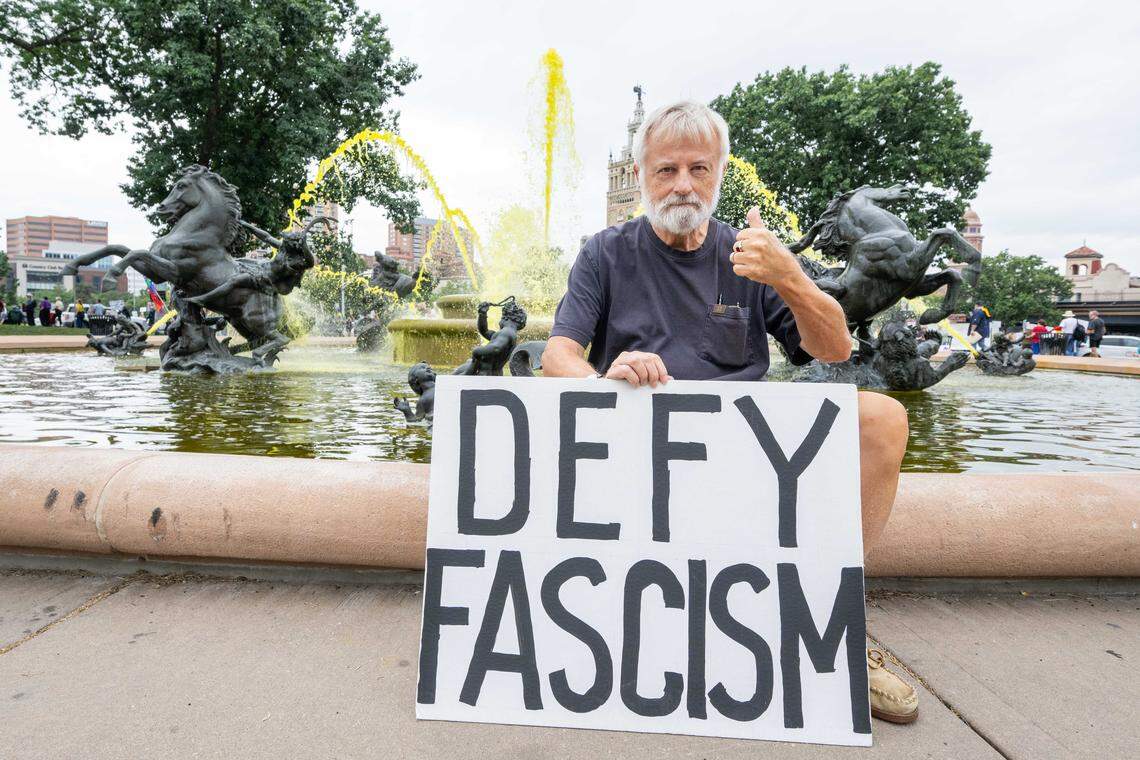Rob Philo of Kansas City holds a sign next to the Mill Street Park fountain during a Labor Day rally put together by several labor unions and organizations, on Monday, Sept. 1, 2025, at Mill Street Park in Kansas City.