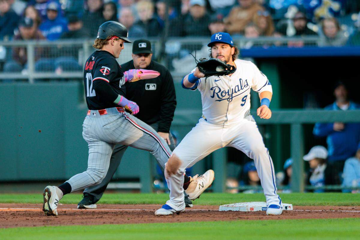Minnesota Twins outfielder Harrison Bader scurries back to first base ahead of a pickoff attempt throw to the Royals’ Vinnie Pasquantino, right, during a Major League Basebal game at Kauffman Stadium on Monday, April 7, 2025.