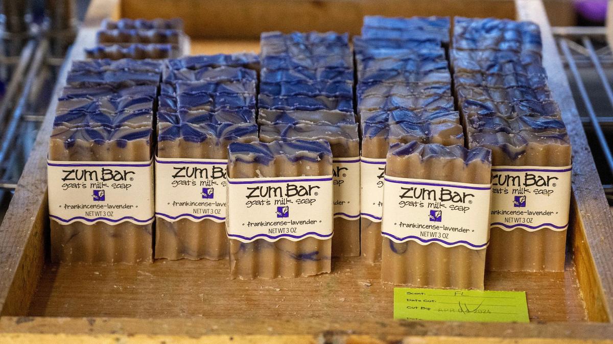 Labeled frankincense-lavender Zum Bar soaps are placed on wooden trays, ready for employees to pack them for orders at the Indigo Wild soap manufacturing plant in Kansas City.