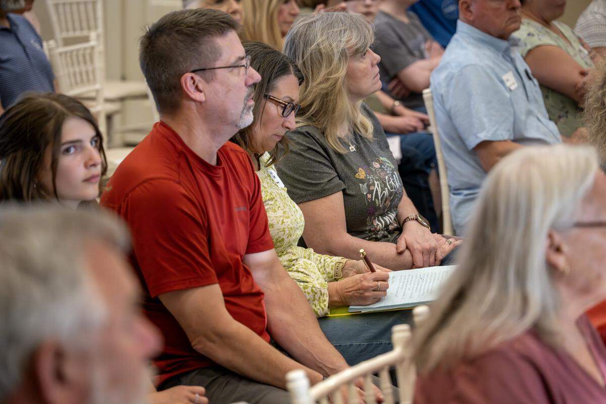 A community member takes notes during a presentation at a town hall meeting at The Rhapsody on Tuesday, June 2, 2026, in Independence. The meeting focused on opposition to the proposed Nebius data center project.