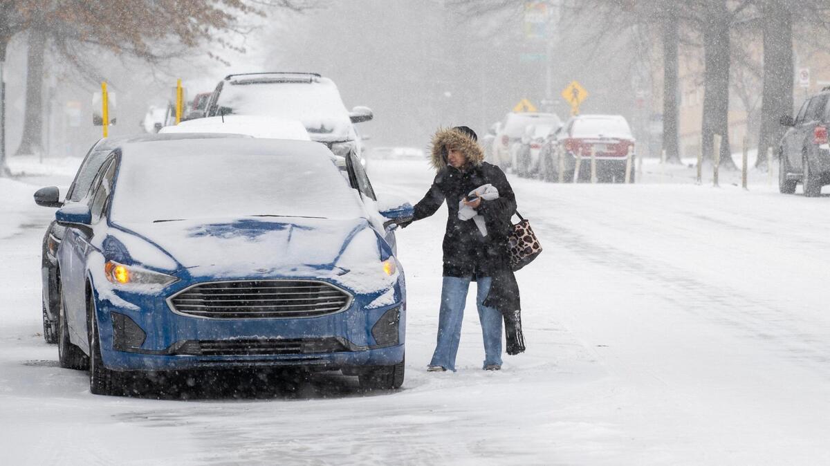 A commuter gets into a car as heavy snow falls on Tuesday, Feb. 18, 2025, in Kansas City.