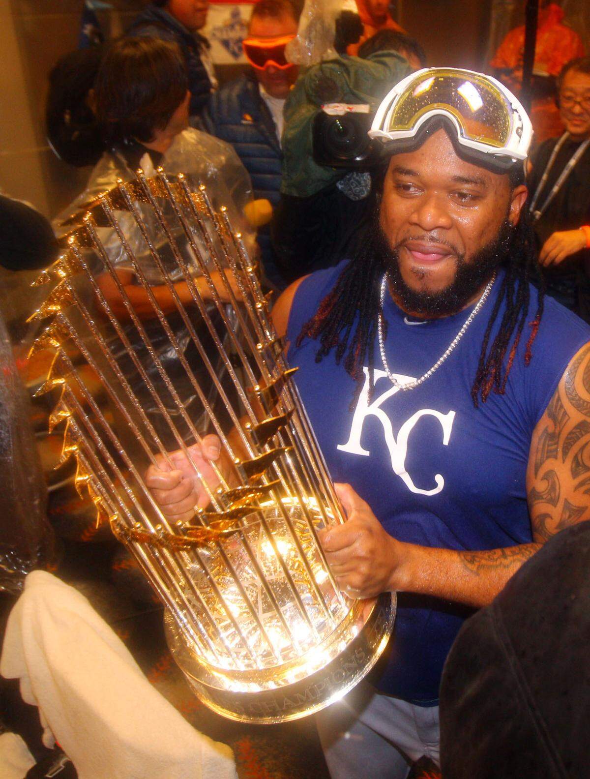 Kansas City Royals starting pitcher Johnny Cueto holds the Commissioners Trophy in the clubhouse after defeating the New York Mets to win game five of the World Series at Citi Field. The Royals win the World Series four games to one.