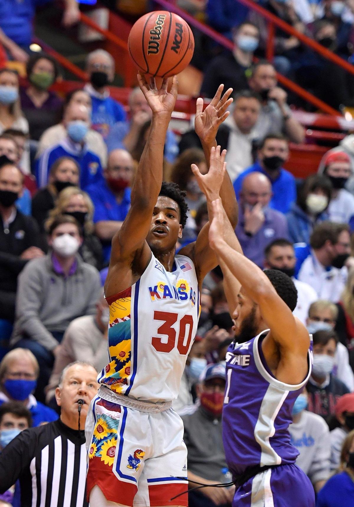 KU’s Ochai Agbaji hits a three-pointer over KSU’s Nijel Pack during Tuesday night’s men’s hoops game at Allen Fieldhouse in Lawrence.