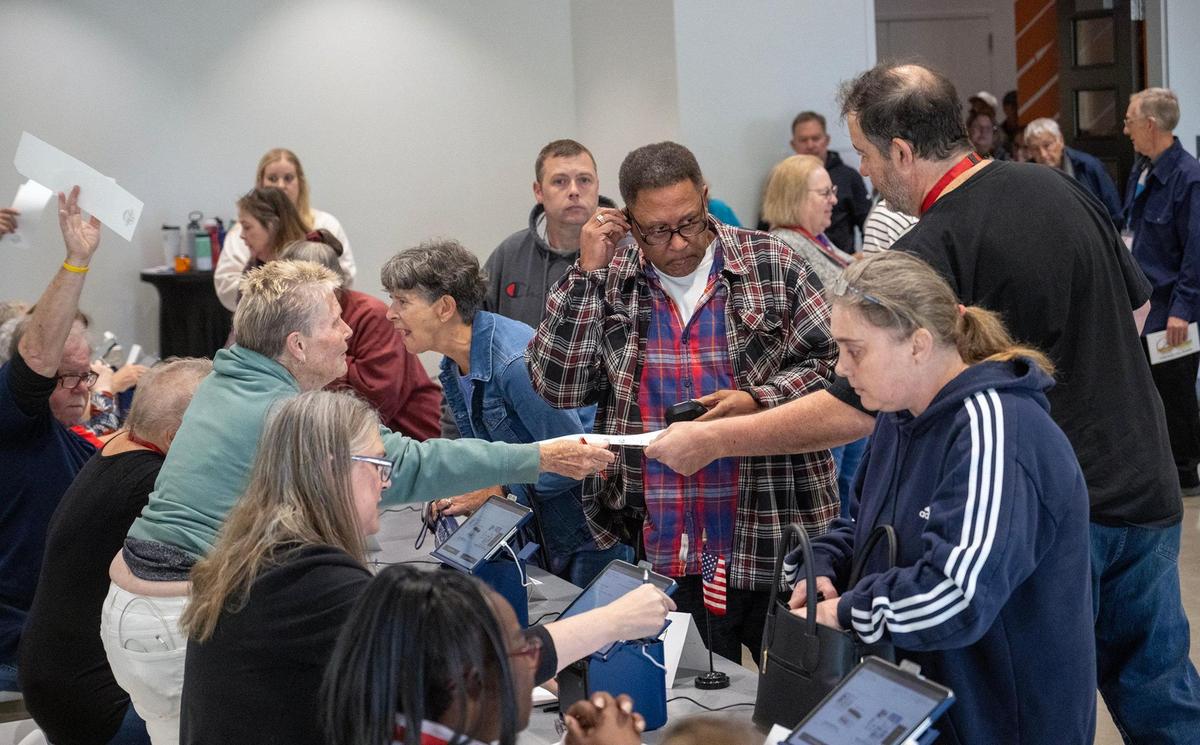 Election workers, left, assisted Johnson County residents who arrived for the first day of in-person advance voting for the 2024 General Election at The Arts and Heritage Center on Saturday, October 19, 2024, in Overland Park.
