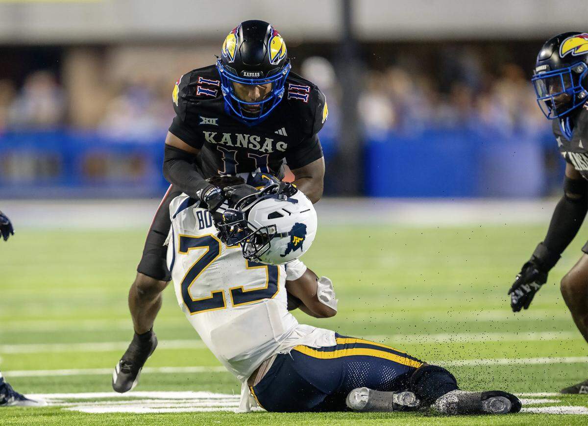 Kansas Jayhawks safety Devin Dye (11) tackles West Virginia Mountaineers running back Cyncir Bowers (23) in the second half of the game at David Booth Kansas Memorial Stadium on Saturday, Sept. 20, 2025, in Lawrence. Dye was ejected from the game for targeting on the play.