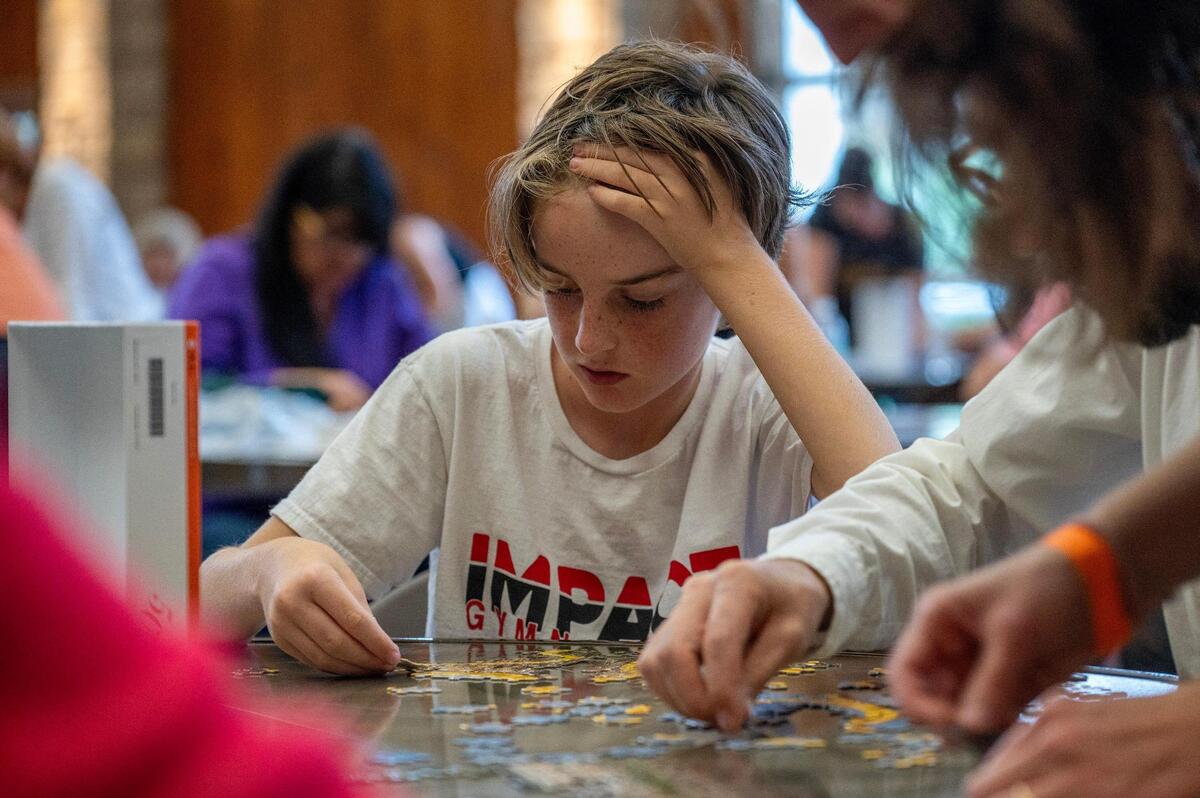 Ten-year-old Elliott Astill works on a 500-piece puzzle with his team, Give Piece A Chance, during the Puzzle Palooza competition at The Lodge at Ironwoods.