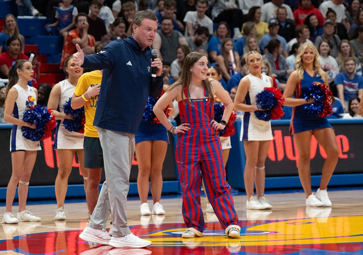 Coach Bill Self talks with Ally Carrier, center, a freshman from Denver, who won $5,000 when Brennan Bechard, director of scouting for the Kansas Jayhawks, made a half-court shot winning $5,000 for her and $10,000 for Levi Hager of Abilene, Kansas, during the 40th annual Late Night in the Phog on Friday, October 18, 2024, at the newly renovated Allen Fieldhouse in Lawrence.