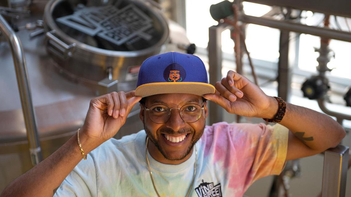 Kemet Coleman, co-owner of Vine Street Brewing Co., stands in front of fermentation tanks used for brewing beer.