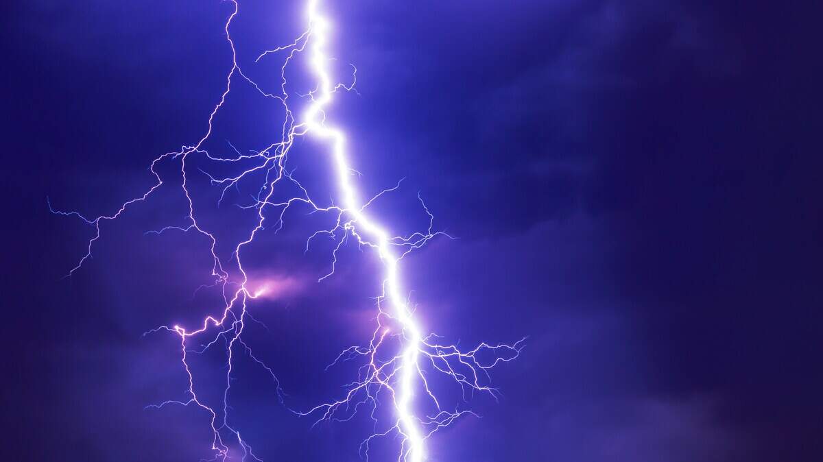 Lighting bolt illuminates the night sky.