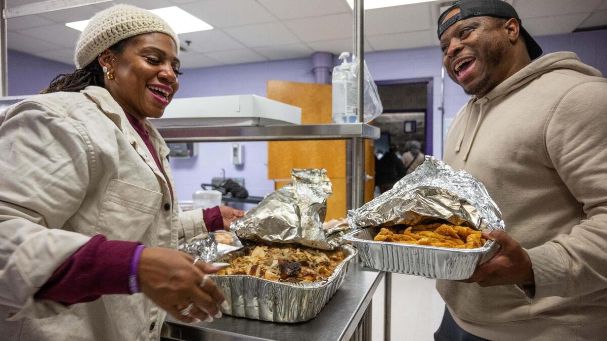 Tamika Pouncil and Charles Parker Jr. collaborate to serve hot meals at the Gregg Klice Community Center in Kansas City on Giving Tuesday. A co-op of organizations on Kansas City’s East Side banded together to distribute meals and clothes to people in the community on the first Tuesday after Thanksgiving for the last eight years.