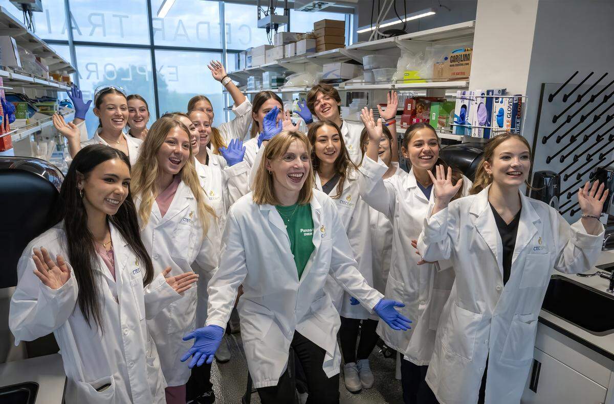 Olympic swimmer and Panasonic ambassador Katie Ledecky, center, takes a photo with students after touring the Bioscience lab at Cedar Trails Exploration Center (CTEC) CAPS in Lenexa on Sept. 30, 2025, where she met and learned from De Soto School District STEM students.