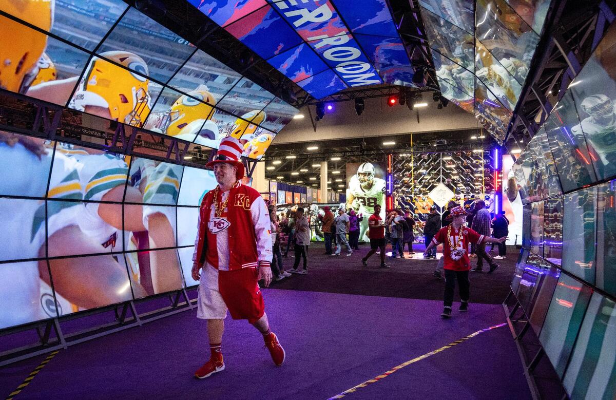 Kansas City Chiefs fans Chris Munsterman and his son, Hudson, 9, of Lake Waukomis, near Kansas City, viewed the Locker Room tunner at the Super Bowl Experience, on Thursday, Feb. 8, 2024, in Las Vegas, Nevada.