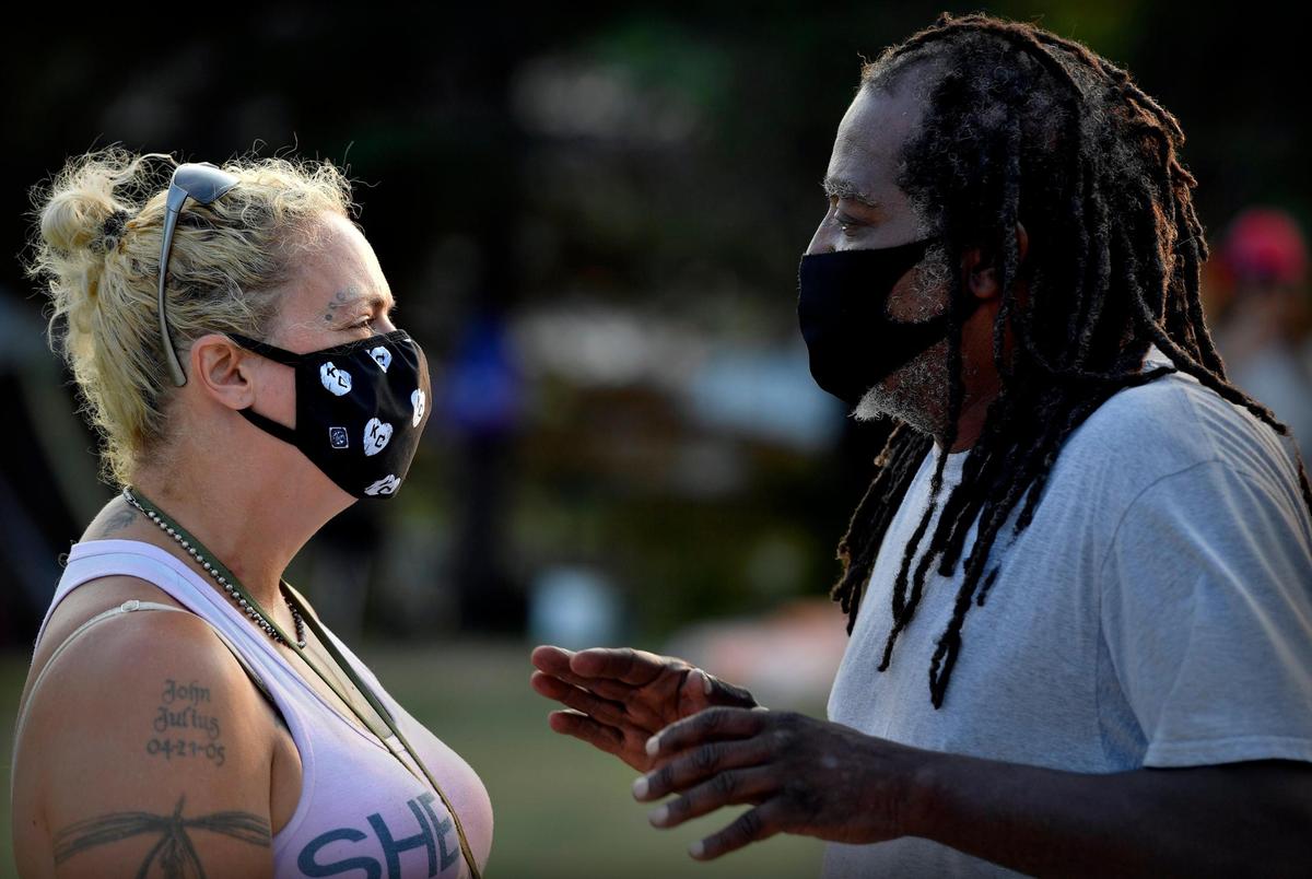 James Shelby, right, who goes by Qadafhi, speaks with Lulu Livingston, whom he met in February after she left an emergency warming shelter at Bartle Hall to join his camp, and then union, on the lawn of City Hall. He quickly made her second in command. “Lulu got the power,” he said, pulling up his sleeve and flexing his bicep. “She’s like a mother hen.”&nbsp;