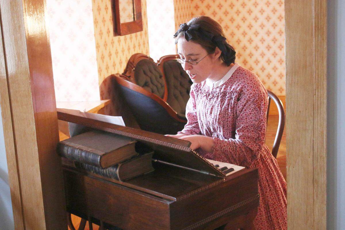 Katie Lange, daily programs coordinator at the Mahaffie Stagecoach Stop and Farm, plays the melodeon while leading participants in songs honoring George Washington.