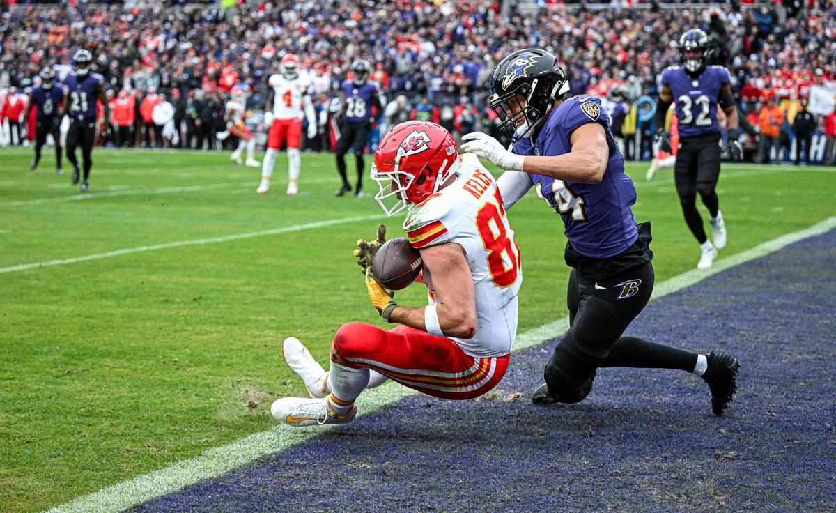 Kansas City Chiefs tight end Travis Kelce (87) comes down with a touchdown catch in front of Baltimore Ravens safety Kyle Hamilton (14) in the first quarter Sunday, Jan. 28, 2024, during the AFC Championship Game in Baltimore.