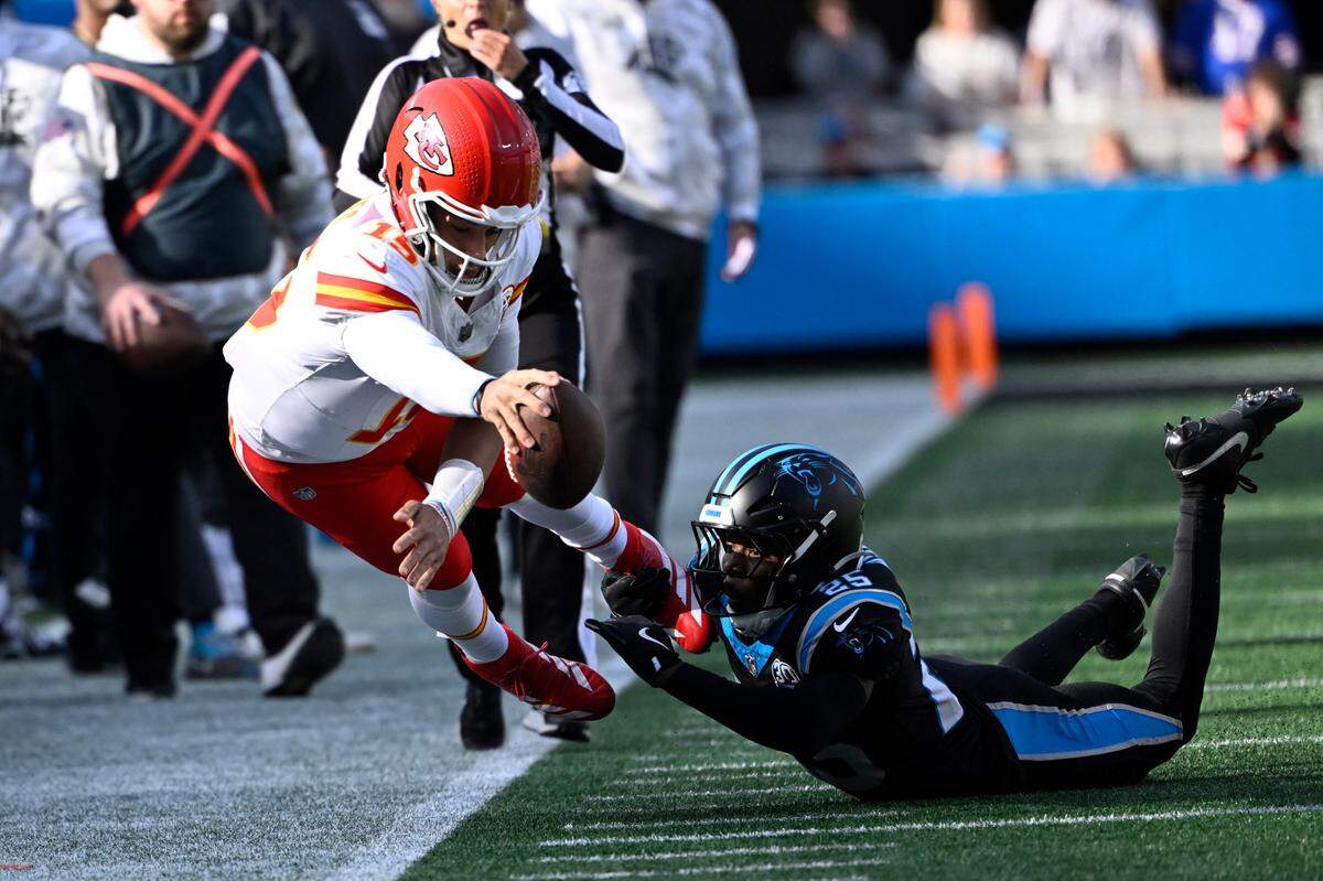 Kansas City Chiefs quarterback Patrick Mahomes (15) dives for the first town as Carolina Panthers safety Xavier Woods (25) defends in the second quarter at Bank of America Stadium. 