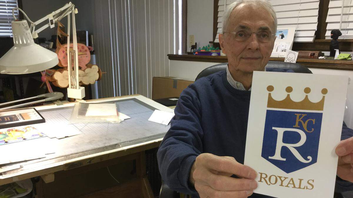 Shannon Manning, 83, holds a copy of the original Royals logo that he created 50 years ago while working as a young artist at Hallmark.