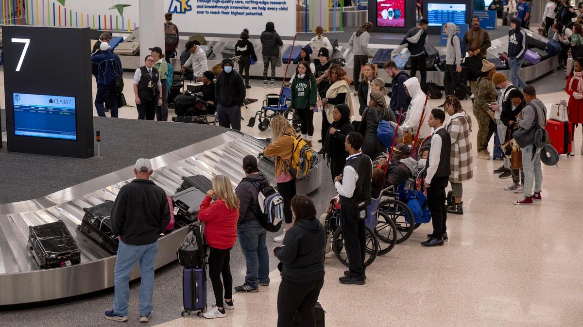 Travelers wait for the bags at baggage carousels at KCI Airport on Wednesday, Nov. 22, 2023, in Kansas City.