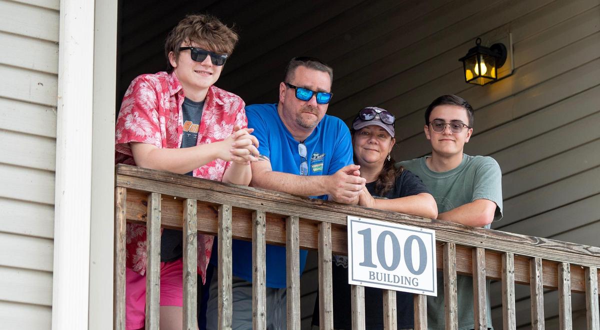 Ryan and Tina Wiley pose for a photo with their son, Vinnie, and his best friend Seth Bundy outside of their timeshare condo.