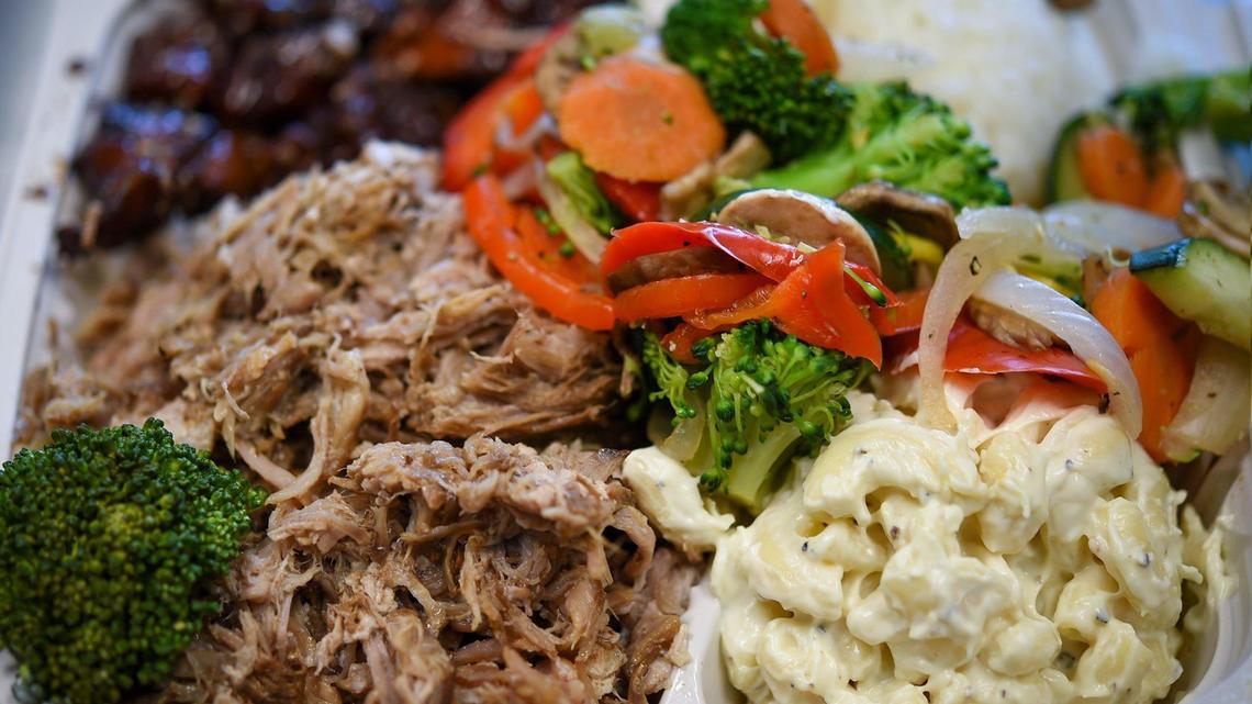 A mixed plate lunch featuring Luau Pig and Honolulu Chicken with macaroni salad and seasoned vegetables at the Hawaiian Bros Island Grill at 8805 State Line Road.
