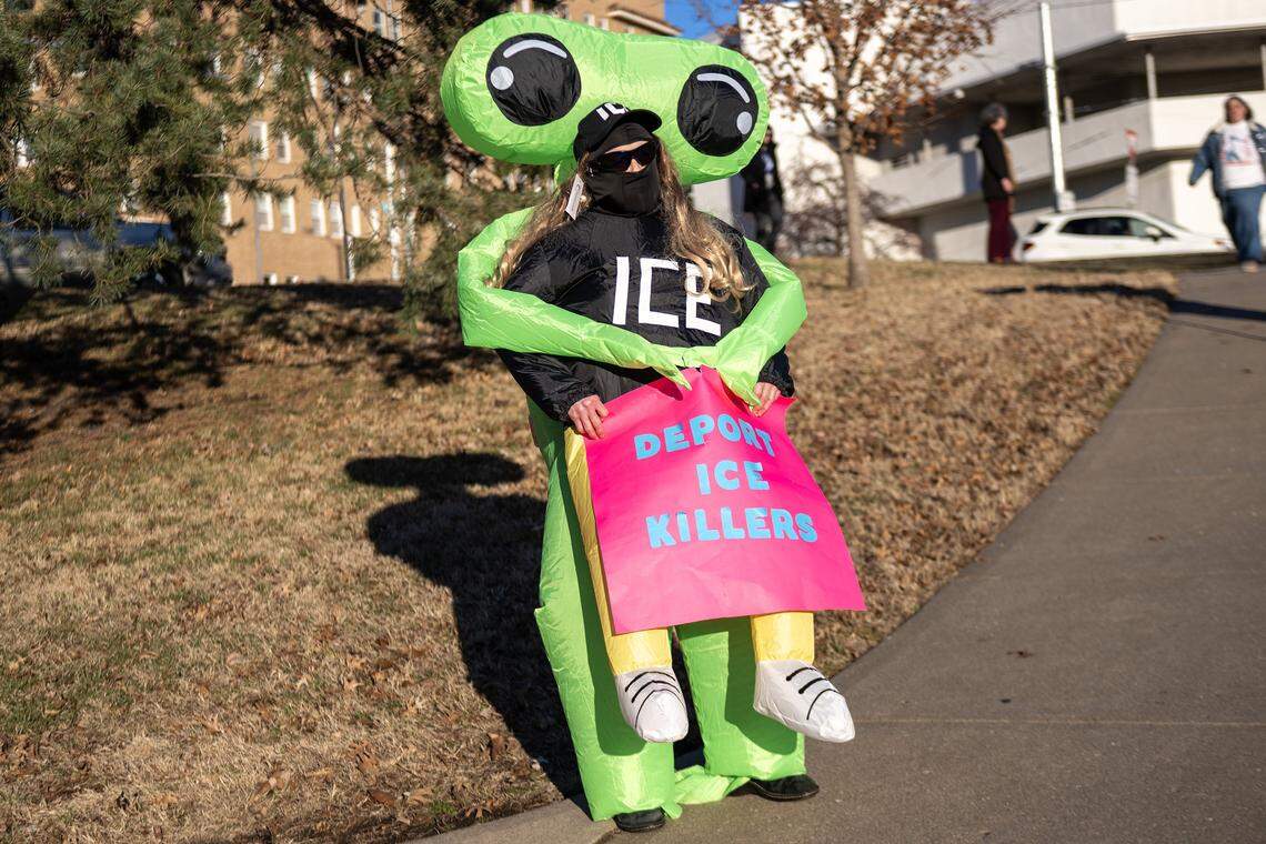 A demonstrator wearing an extraterrestrial costume participates in a vigil for victims of U.S. Immigration and Customs Enforcement at Mill Creek Park on Saturday, Jan. 10, 2026, in Kansas City.