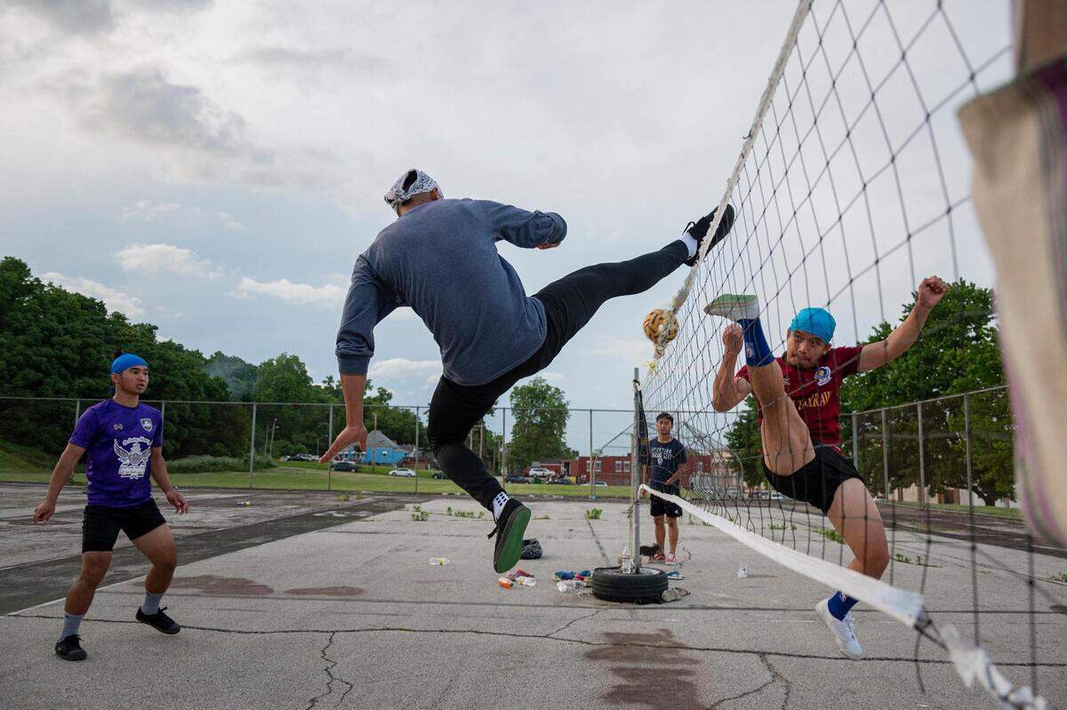 Lah Wah and Day Lo fight for the ball at the net as they play chinlone at Sheffield Park in Kansas City on June 5, 2022.