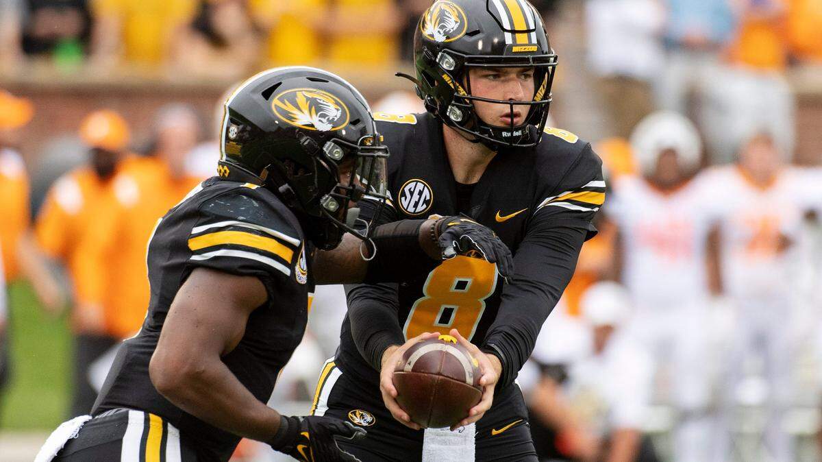 Missouri quarterback Connor Bazelak, right, hands the ball off to running back Tyler Badie, left, during the first half of an NCAA college football game against Tennessee Saturday, Oct. 2, 2021, in Columbia, Mo. (AP Photo/L.G. Patterson)
